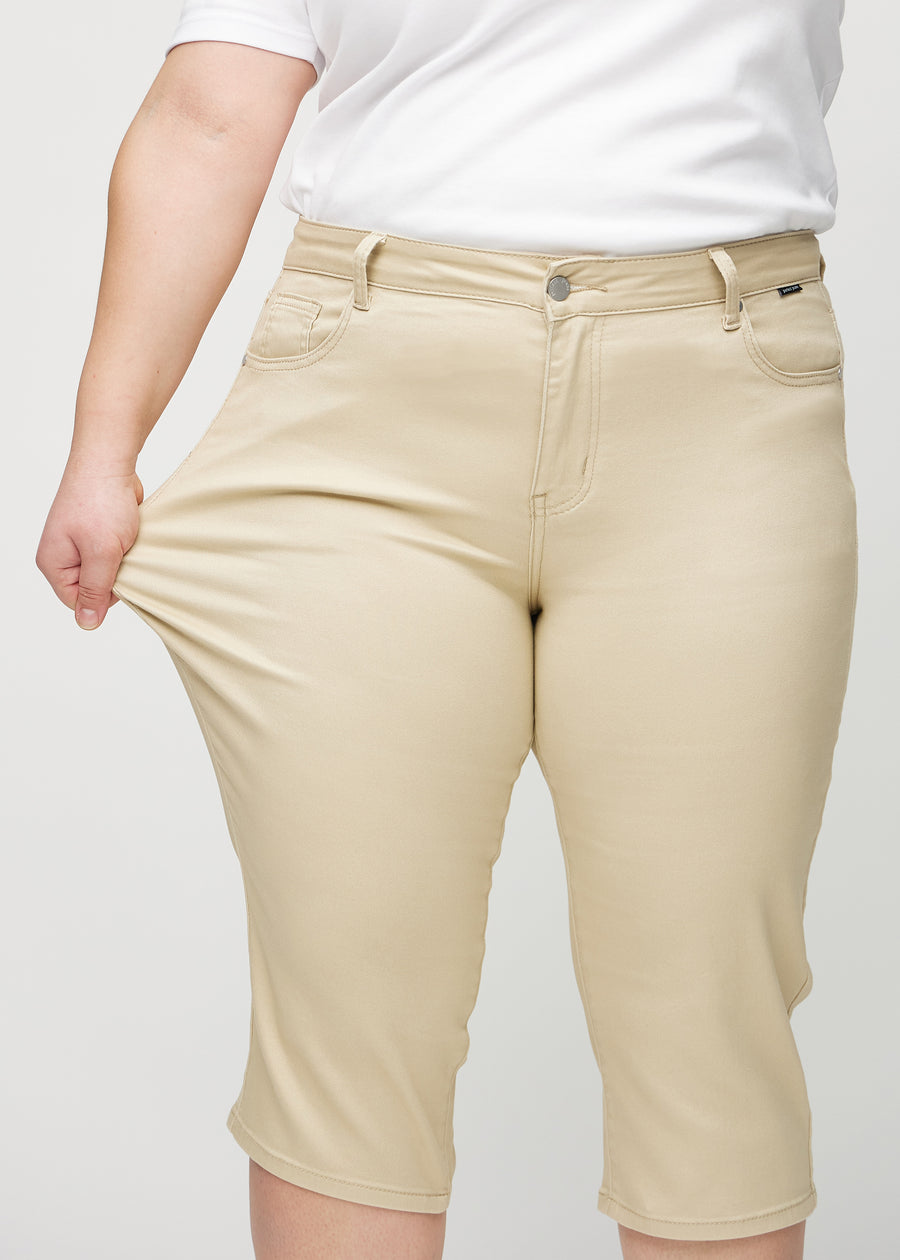 Plus-size-modellen strekker capriene ved låret for å vise stretch.