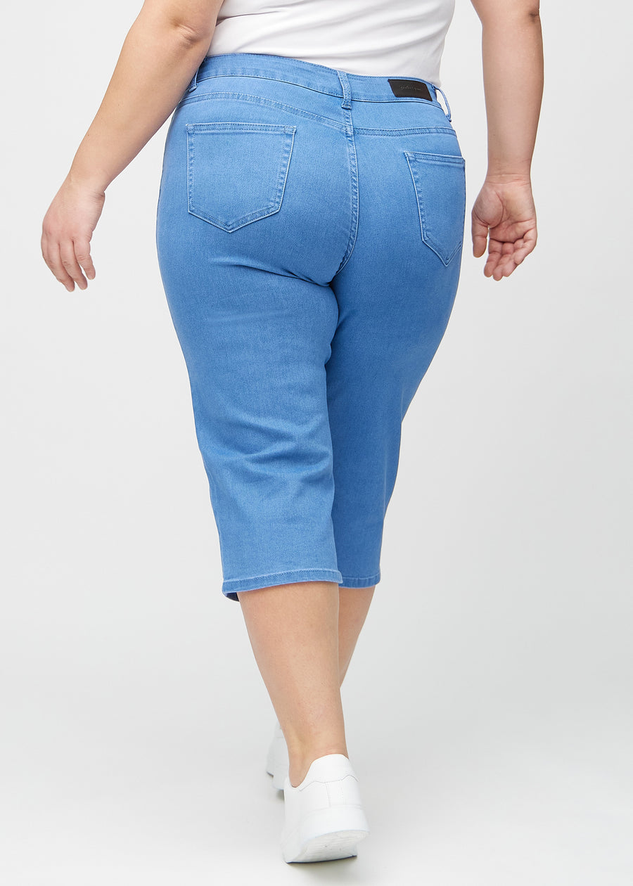 Blå regular capris sett bakfra på en plus-size-modell, så man kan se hele produktet.