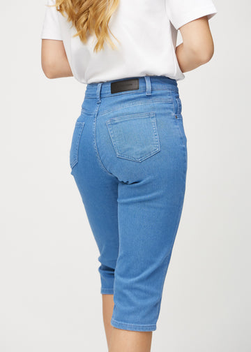 Blå regular capris sett bakfra på nært hold for å vise detaljer.