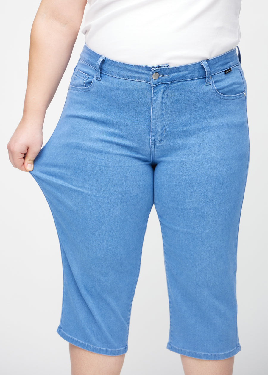 Plus-size-modellen strekker caprisene ved låret for å vise stretch.