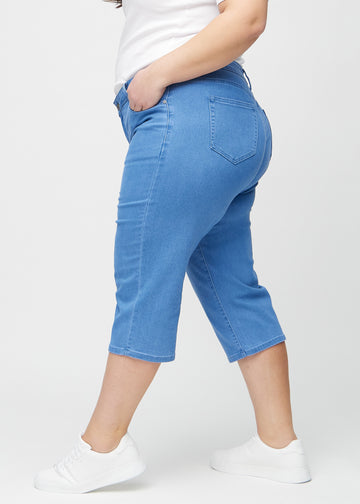 Blå regular capris sett fra siden på en plus-size-modell.