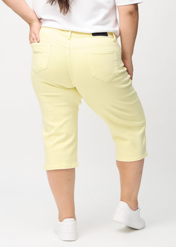 Lysegule regular capris sett bakfra på en plus-size-modell, så man kan se hele produktet.