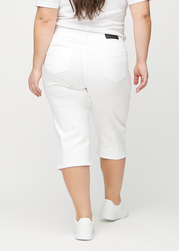 Hvite regular capris sett bakfra på en plus-size-modell, slik at man kan se hele produktet.