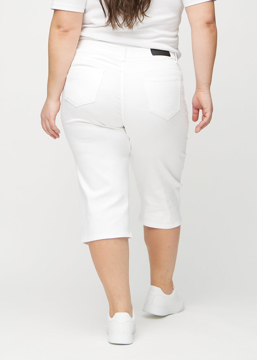 Hvite regular capris sett bakfra på en plus-size-modell, slik at man kan se hele produktet.