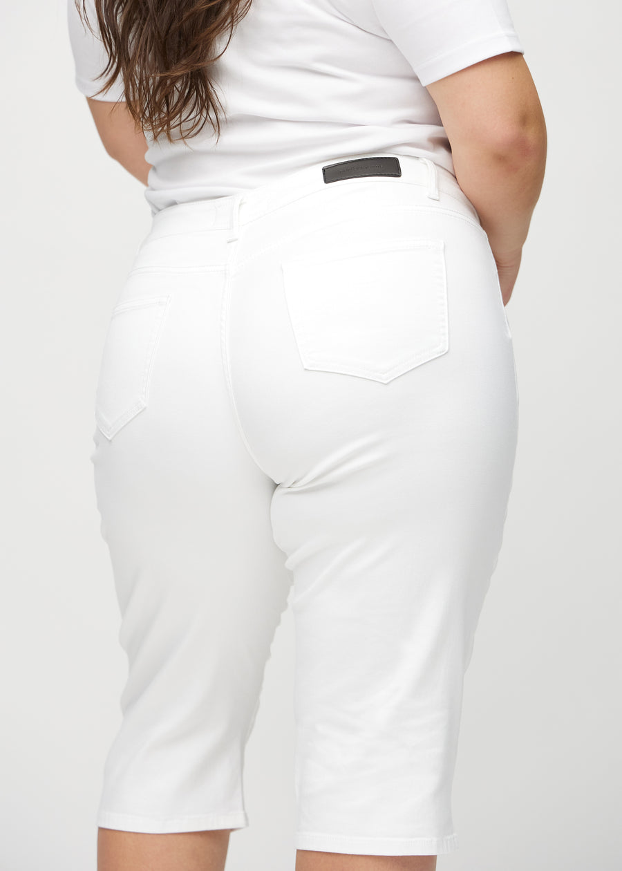 Hvite regular capris sett bakfra på nært hold på en plus-size-modell for å vise detaljer.