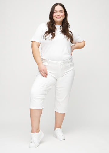 Fullt bilde av en plus-size-modell i hvite regular capris.