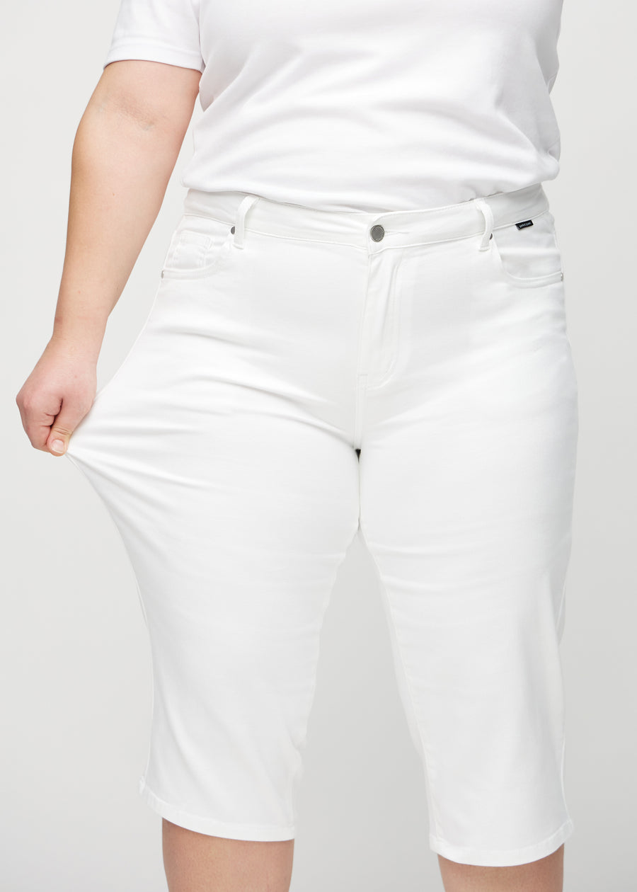 Plus-size-modellen strekker caprisene ved låret for å vise stretch.