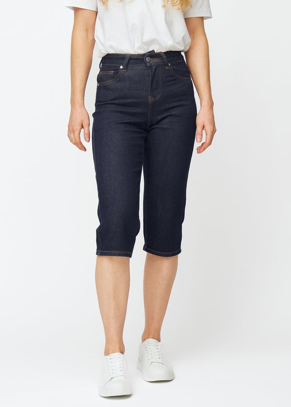 Dyp mørkeblå denim capris til dame i fargen Midnights med regular passform som sitter ved hoften og faller mer rett ned over bena, sett forfra.