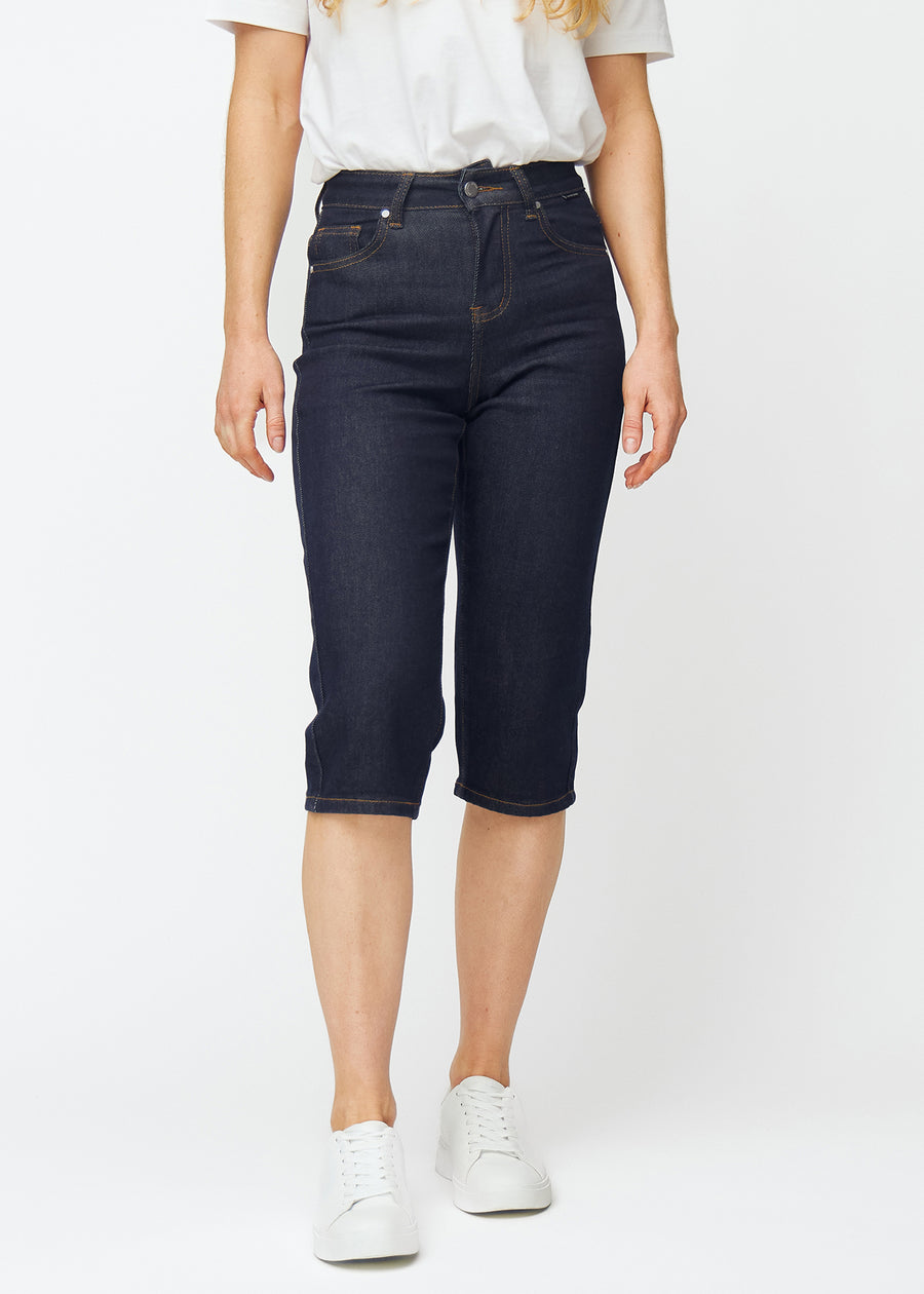 Dyp mørkeblå denim capris til dame i fargen Midnights med regular passform som sitter ved hoften og faller mer rett ned over bena, sett forfra.