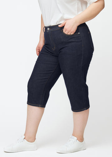 Dyp mørkeblå denim capris til dame i fargen Midnights med regular passform sett fra siden på plus-size modell.