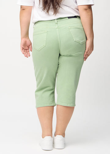Lysegrønne regular capris sett bakfra på en plus-size-modell, så man kan se hele produktet.