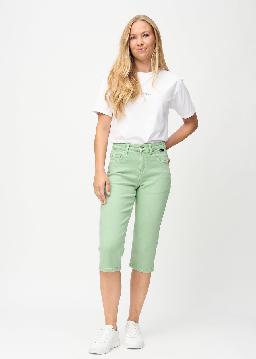 Fullt bilde av modell i lysegrønne regular capris.