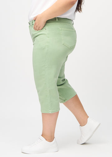 Lysegrønne regular capris sett fra siden på en plus-size-modell.