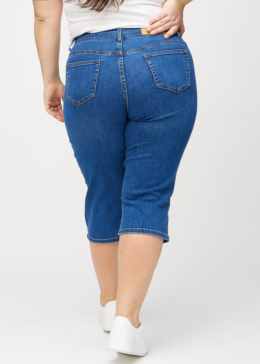 Mørk denim regular capris sett bakfra på en plus-size modell, så man kan se hele produktet.