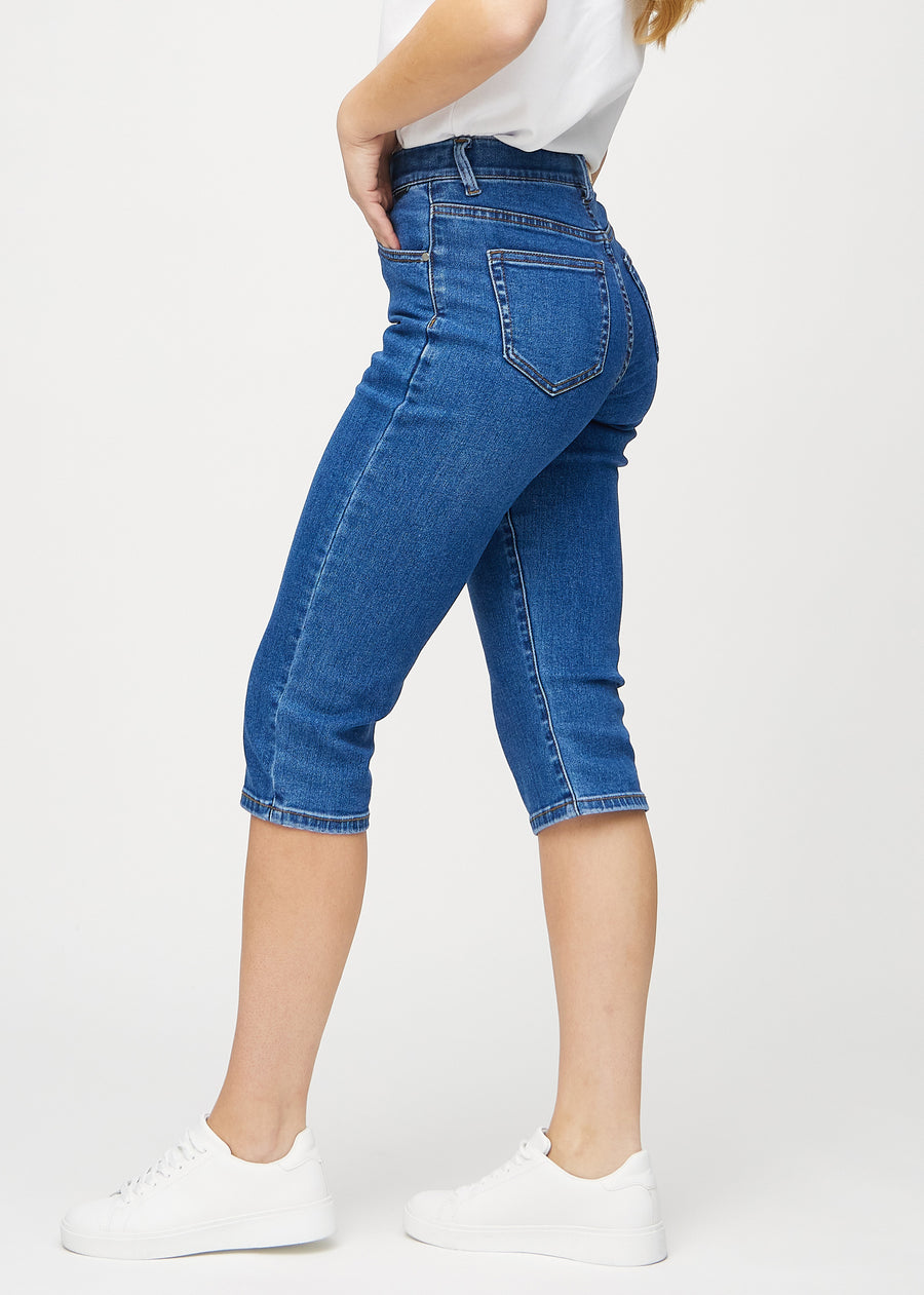 Mørk denim regular capris sett fra siden på modell.