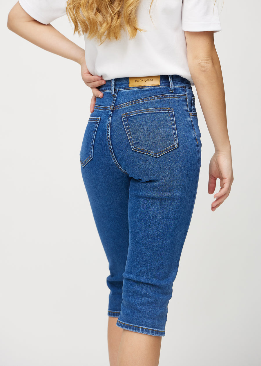 Mørk denim regular capris sett bakfra på nært hold for å vise detaljer.
