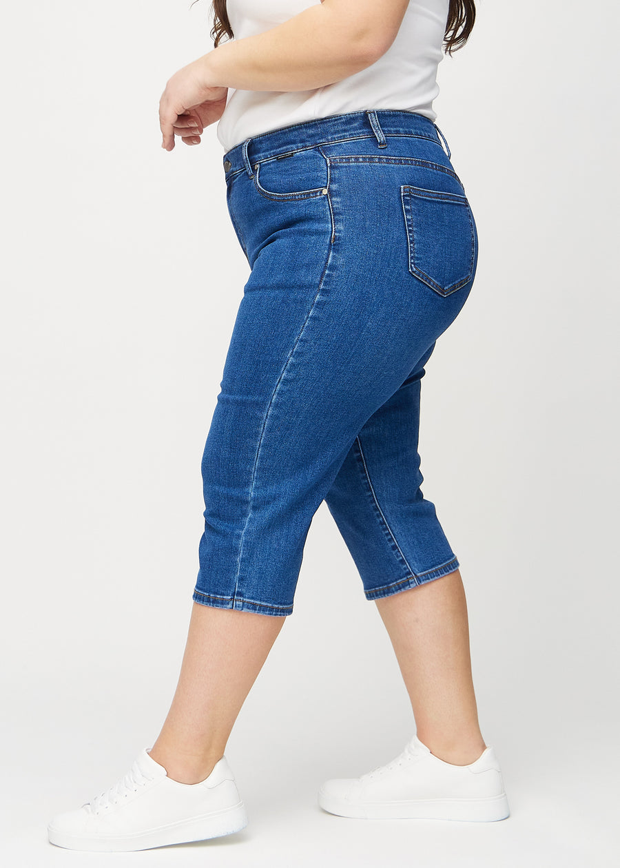 Mørk denim regular capris sett fra siden på en plus-size modell.