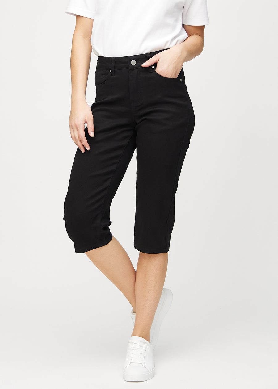 Svarte regular capris, modellnavn Ravens, som sitter tett langs benet og slutter rett under kneet, sett forfra.