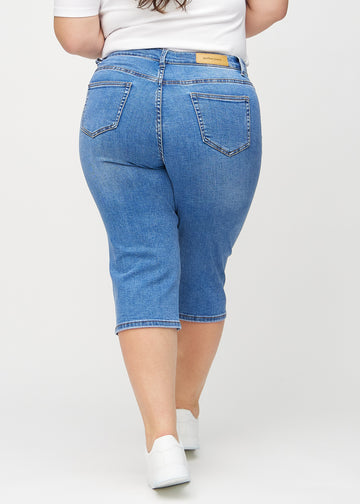 Denim regular capris sett bakfra på en plus-size-modell, så man kan se hele produktet.