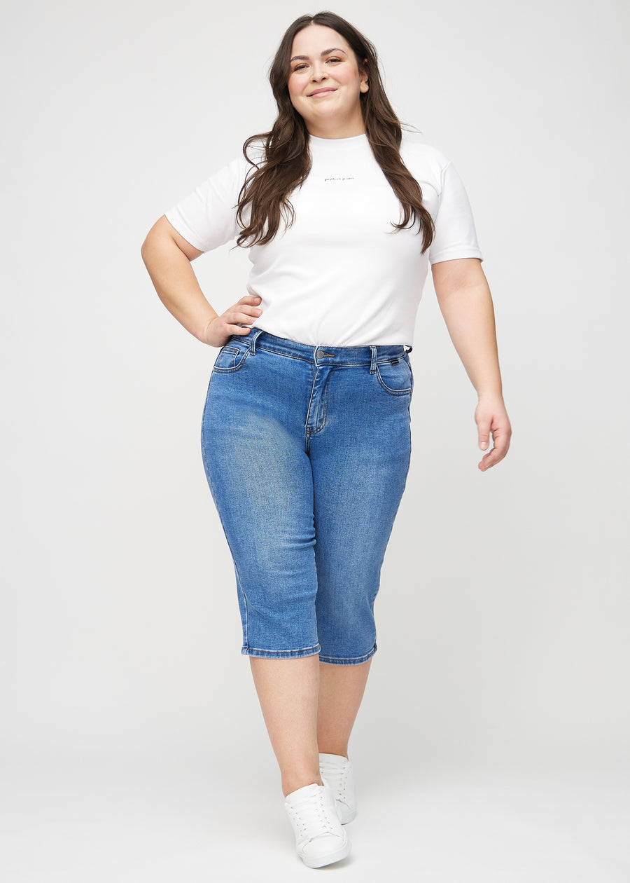 Fullt bilde av en plus-size-modell i denim regular capris.