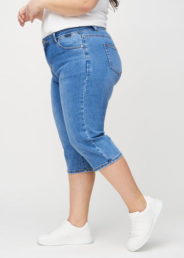 Denim regular capris sett fra siden på en plus-size-modell.