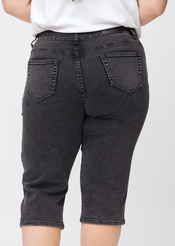 Mørkegrå denim regular capris sett bakfra på nært hold på en plus-size-modell for å vise detaljer.