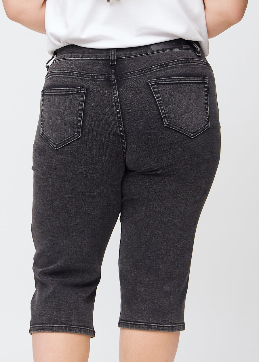 Mørkegrå denim regular capris sett bakfra på nært hold på en plus-size-modell for å vise detaljer.