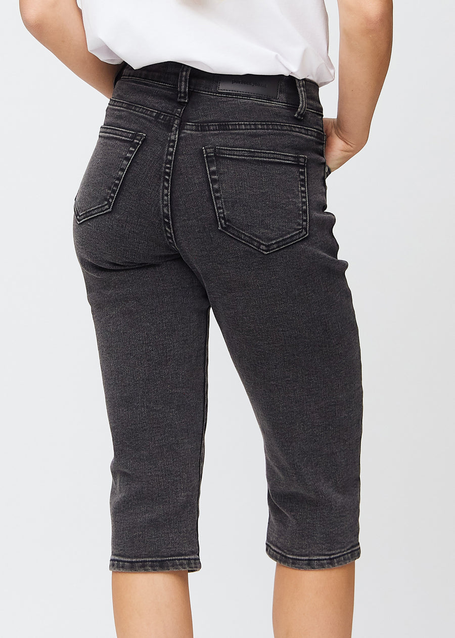 Mørkegrå denim regular capris sett bakfra på nært hold for å vise detaljer.