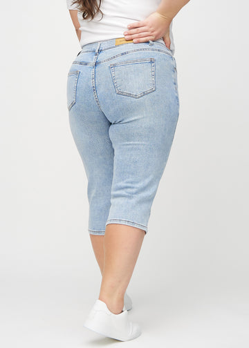 Lys denim regular capris sett bakfra på en plus-size-modell, slik at man kan se hele produktet.