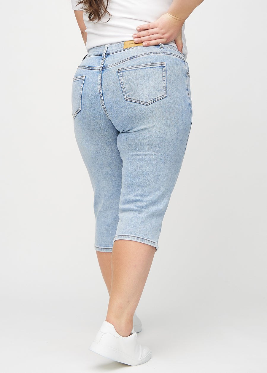 Lys denim regular capris sett bakfra på en plus-size-modell, slik at man kan se hele produktet.