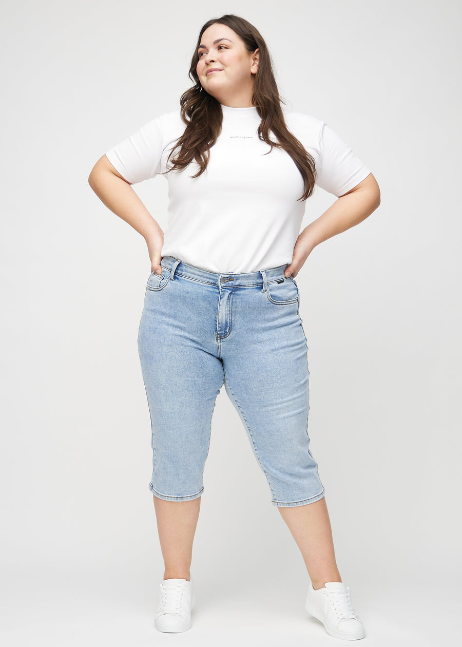 Fullt bilde av en plus-size-modell i lys denim regular capris.