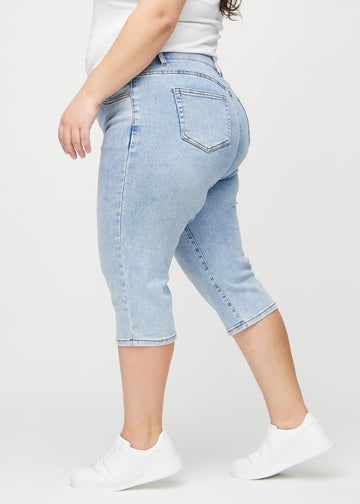 Lys denim regular capris sett fra siden på en plus-size-modell.