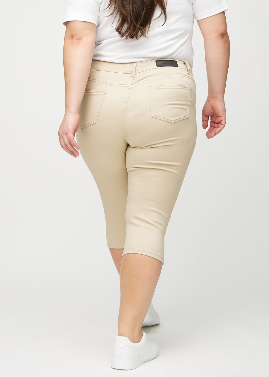 Skinny-capris til kvinner i beige jeansstoff, fargen Gazelles. Sett bakfra på en plus size-modell, med fokus på passform og baklommer.