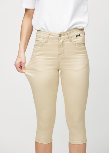 Skinny-capris til kvinner i beige jeansstoff, fargen Gazelles. En modell strekker stoffet for å vise fleksibiliteten.