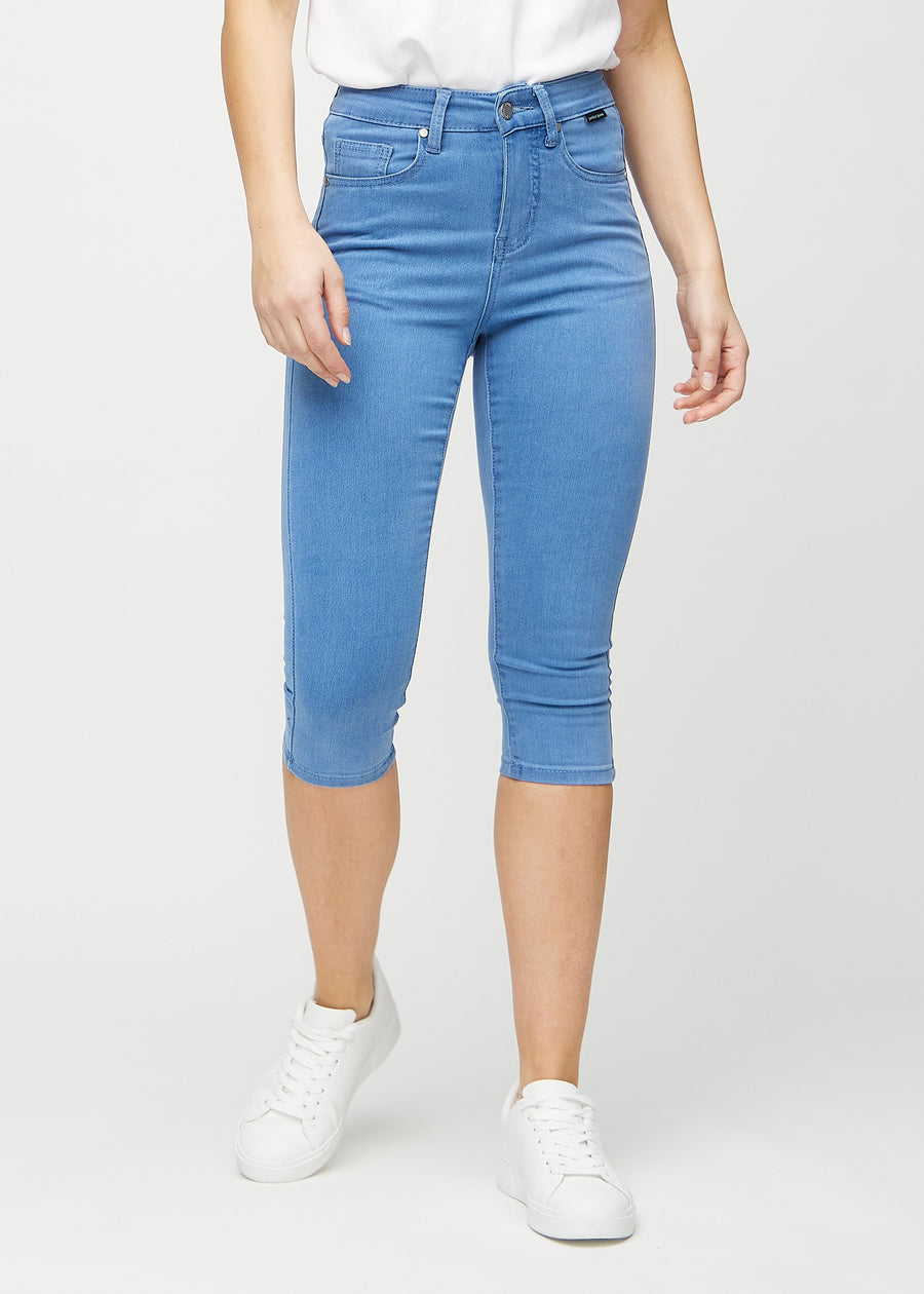Skinny-capris til kvinner i blått jeansstoff, fargen Geraniums. Sett forfra på en modell, med tettsittende ben til rett under kneet.