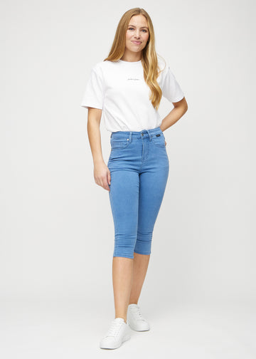Skinny-capris til kvinner i blått jeansstoff, fargen Geraniums. Helhetsbilde av en modell med capris på.