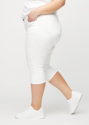 Skinny-capris til kvinner i hvitt jeansstoff, fargen Marguerites. Sett fra siden på en plus size-modell, med tettsittende passform.