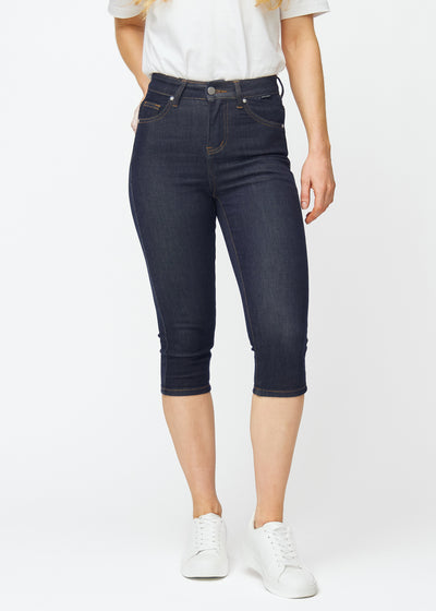Dyp mørkeblå denim capris til dame i fargen Midnights med skinny passform som sitter tett fra hoften til under kneet, sett forfra.
