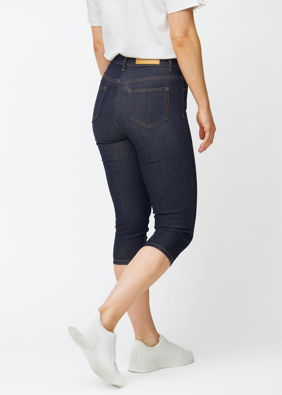 Dyp mørkeblå denim capris til dame i fargen Midnights sett bakfra på plus-size modell.