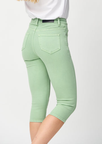 Skinny-capris til kvinner i pastellgrønt jeansstoff, fargen Mints. Nærbilde bakfra på en modell, med fokus på lommer og sømmer.