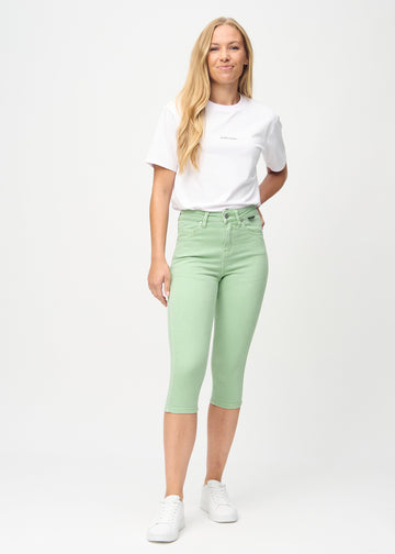 Skinny-capris til kvinner i pastellgrønt jeansstoff, fargen Mints. Helhetsbilde av en modell med capris på.