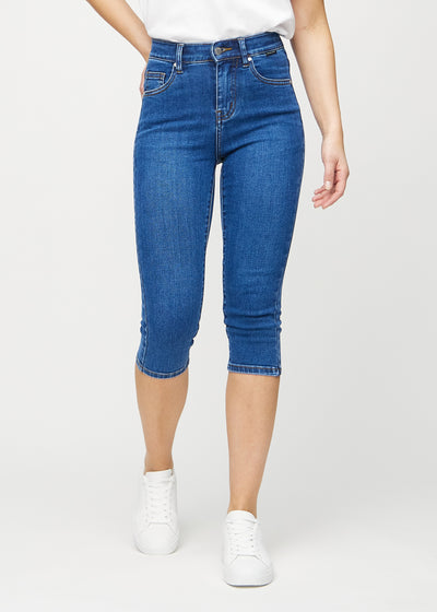 Skinny-capris til kvinner i mørkeblå denim, fargen Oceans. Sett forfra på en modell, med tettsittende ben til rett under kneet.