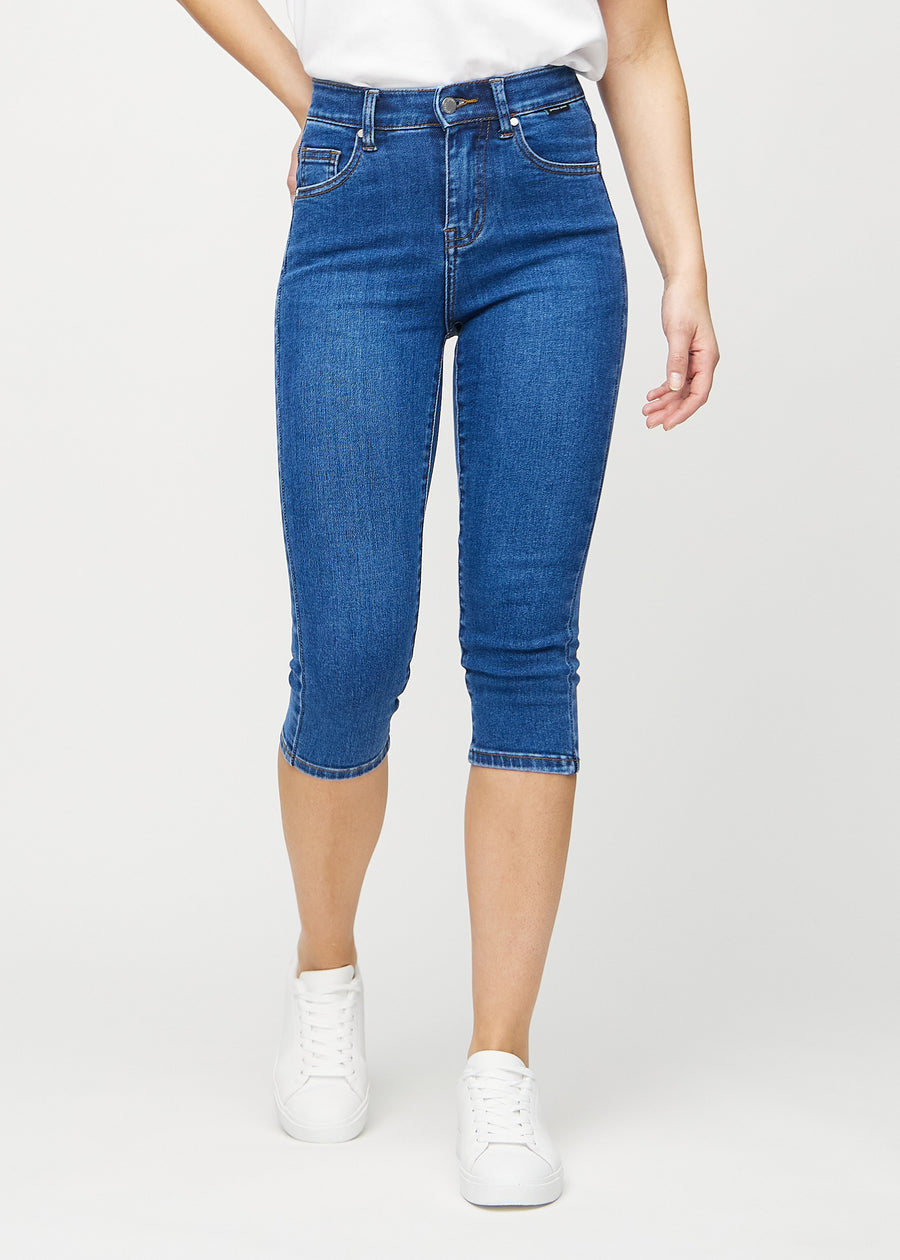 Skinny-capris til kvinner i mørkeblå denim, fargen Oceans. Sett forfra på en modell, med tettsittende ben til rett under kneet.