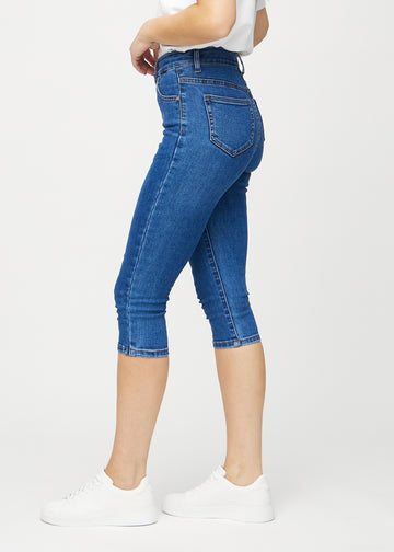 Skinny-capris til kvinner i mørkeblå denim, fargen Oceans. Sett fra siden på en modell, med tettsittende passform.