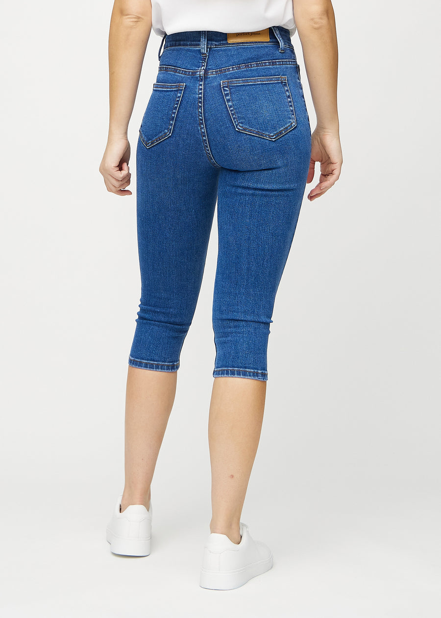 Skinny-capris til kvinner i mørkeblå denim, fargen Oceans. Sett bakfra på en modell, med fokus på passform og baklommer.