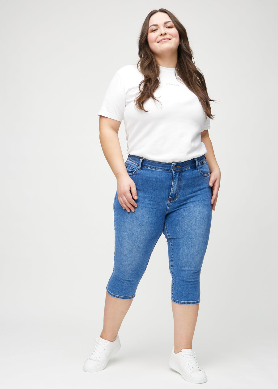 Skinny-capris til kvinner i blå denim, fargen Rivers. Helhetsbilde av en plus size-modell med capris på.