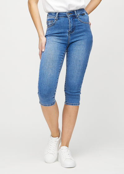 Skinny-capris til kvinner i blå denim, fargen Rivers. Sett forfra på en modell, med tettsittende ben til rett under kneet.