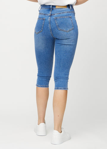 Skinny-capris til kvinner i blå denim, fargen Rivers. Sett bakfra på en modell, med fokus på passform og baklommer.