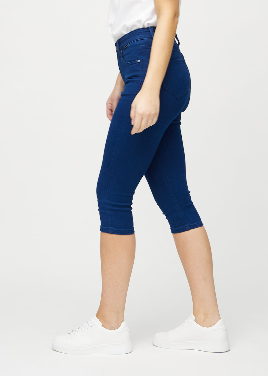 Skinny-capris til kvinner i mørkeblått jeansstoff, fargen Royals. Sett fra siden på en modell, med tettsittende passform.