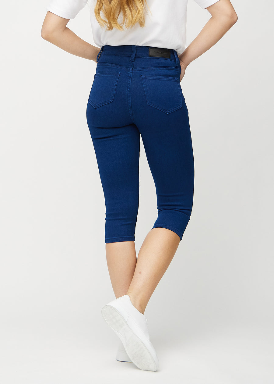 Skinny-capris til kvinner i mørkeblått jeansstoff, fargen Royals. Sett bakfra på en modell, med fokus på passform og baklommer.
